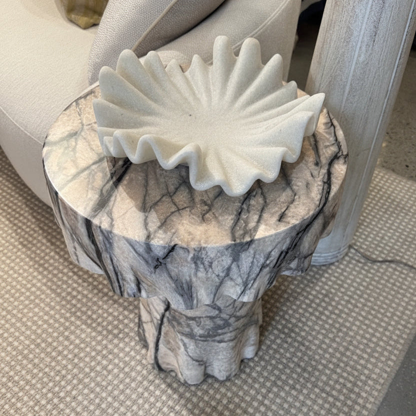Decorative stool with marble-like pattern and ruffled top in a store setting