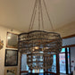 Large decorative chandelier hanging in a room with mirrors and windows.