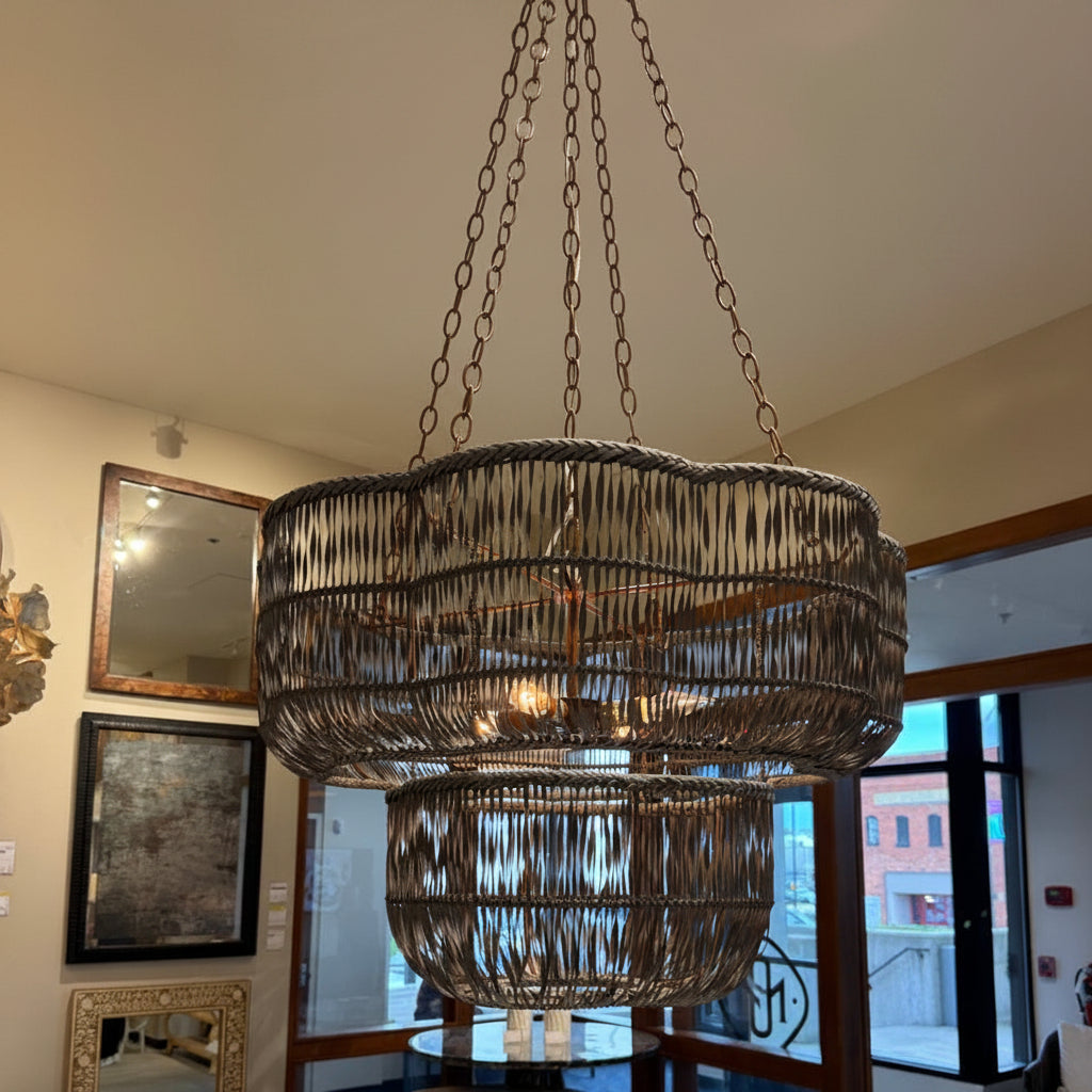 Large decorative chandelier hanging in a room with mirrors and windows.