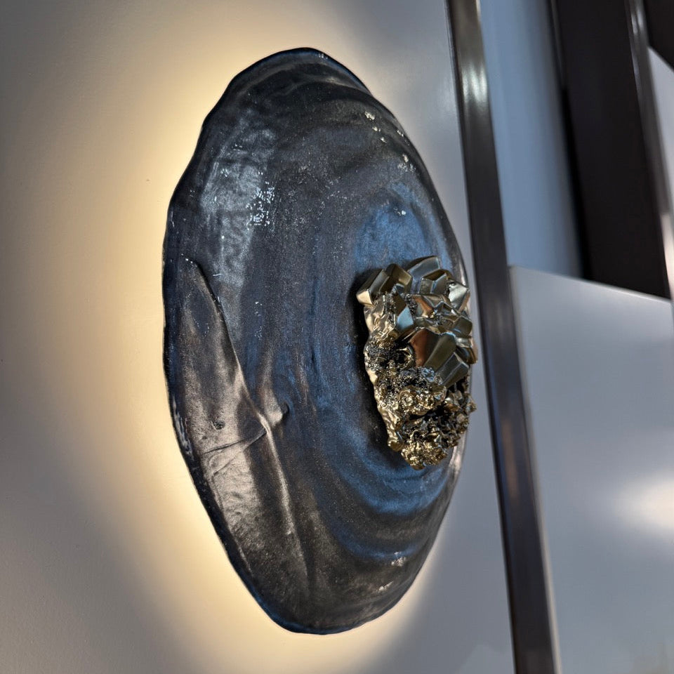 Close-up of a metallic object with a textured surface on a reflective surface.