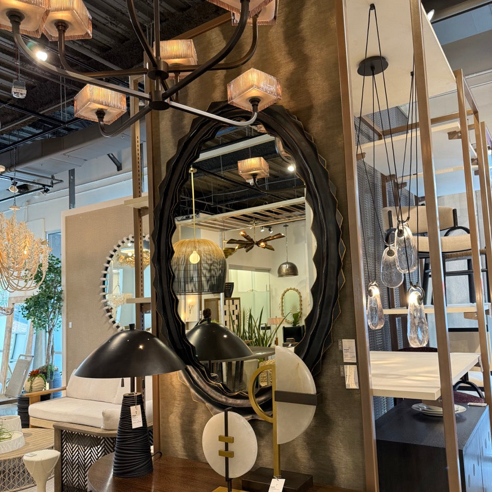 Furniture store interior with mirrors, lamps, and decorative items on display.