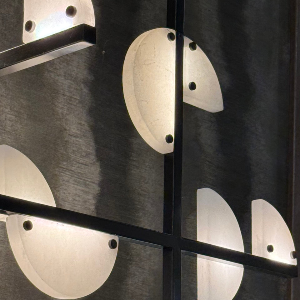 Close-up of a modern wall light fixture with circular glass shades.
