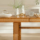 Wooden table with decorative items in a room with white walls and wooden floor.