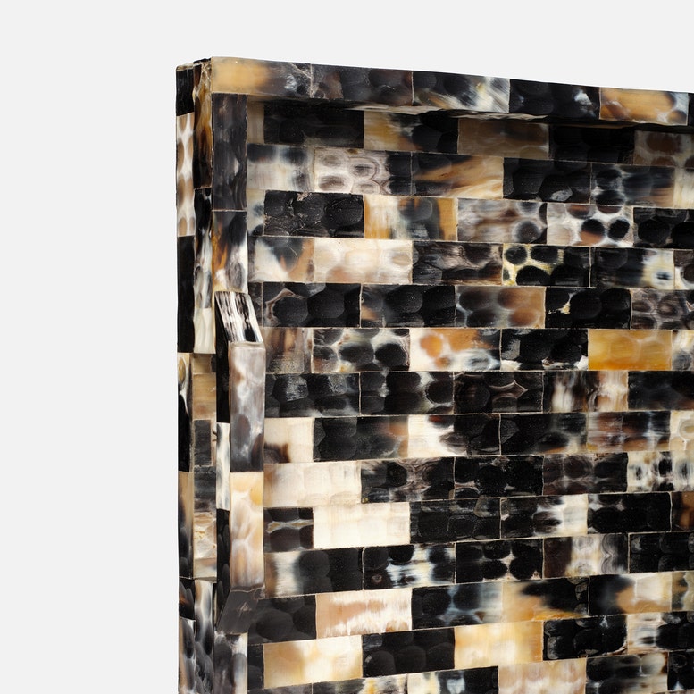 Decorative wall art with a mosaic pattern of black, brown, and beige tiles on a white background.
