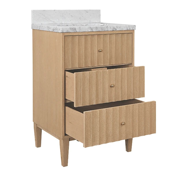 A three-drawer bathroom vanity cabinet in a light natural wood finish with small round metallic knobs, topped with a white marble countertop and backsplash, shown on a plain white background.