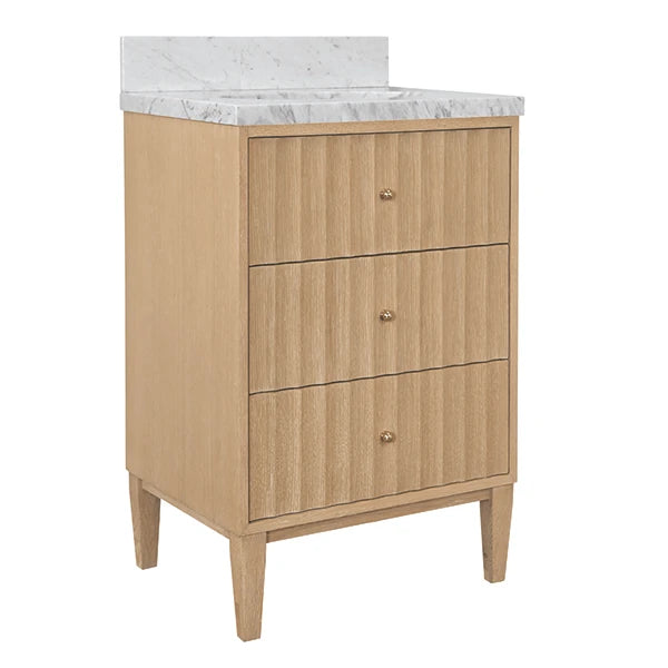 A three-drawer bathroom vanity cabinet in a light natural wood finish with small round metallic knobs, topped with a white marble countertop and backsplash, shown on a plain white background.