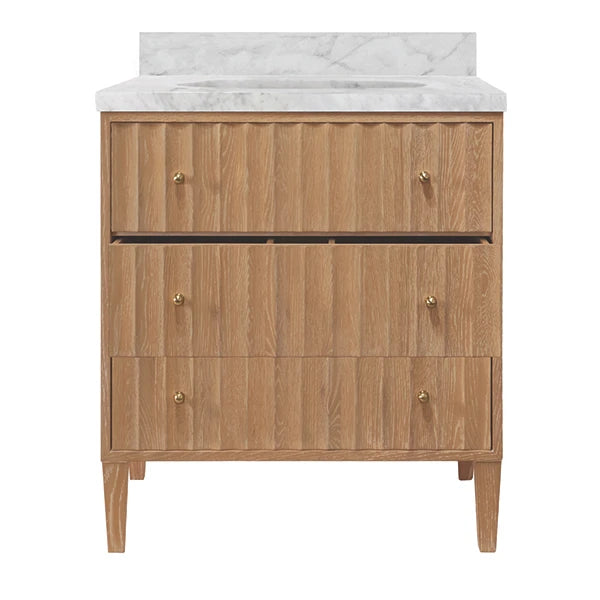 A three-drawer wooden vanity cabinet with a white marble countertop and backsplash, featuring small brass knobs and tapered legs, shown against a plain white background.