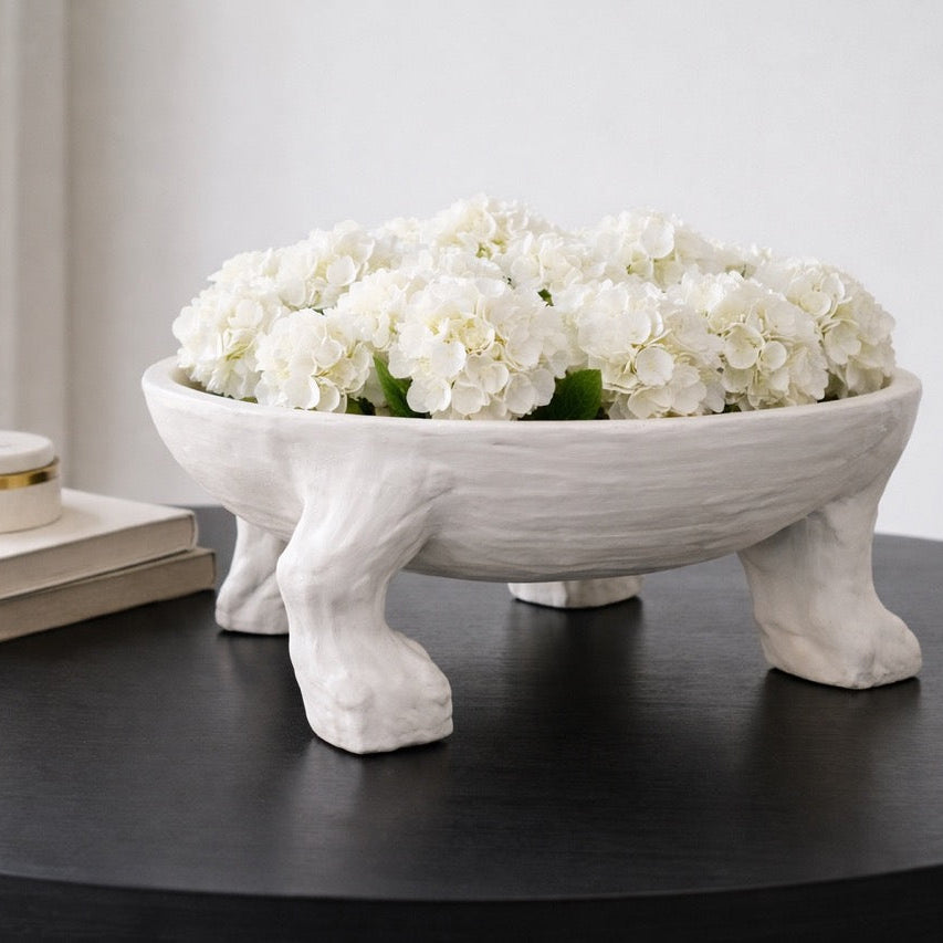 Decorative bowl with white flowers on a dark surface