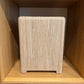 Wooden stool with woven seat in a wooden cabinet setting