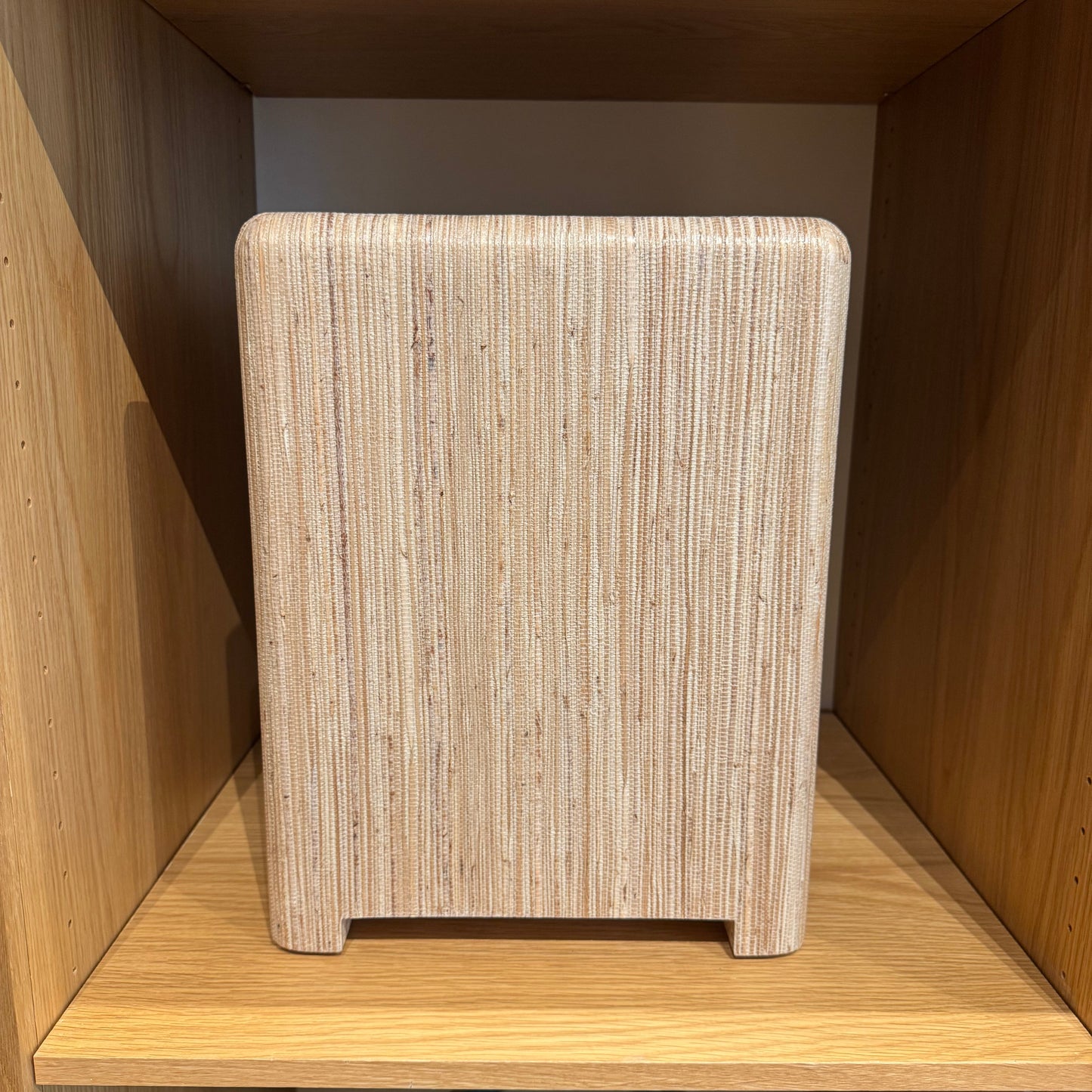 Wooden stool with woven seat in a wooden cabinet setting