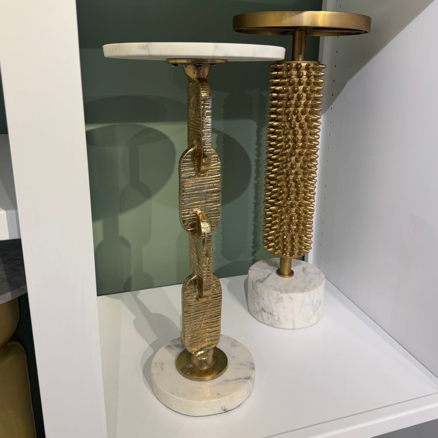 Decorative objects on a shelf with marble and gold finishes.