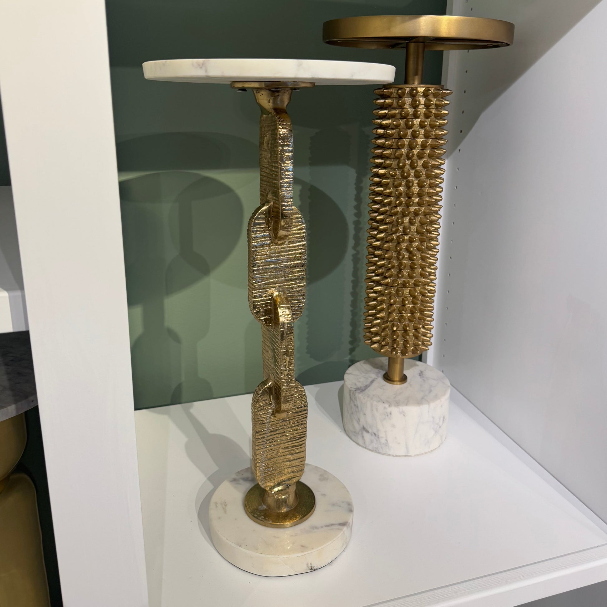 Decorative objects on a shelf with marble and gold finishes.