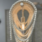 Close-up of a decorative pendant light with textured chain design against a neutral background