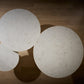 Three round, light-colored objects on a wooden floor