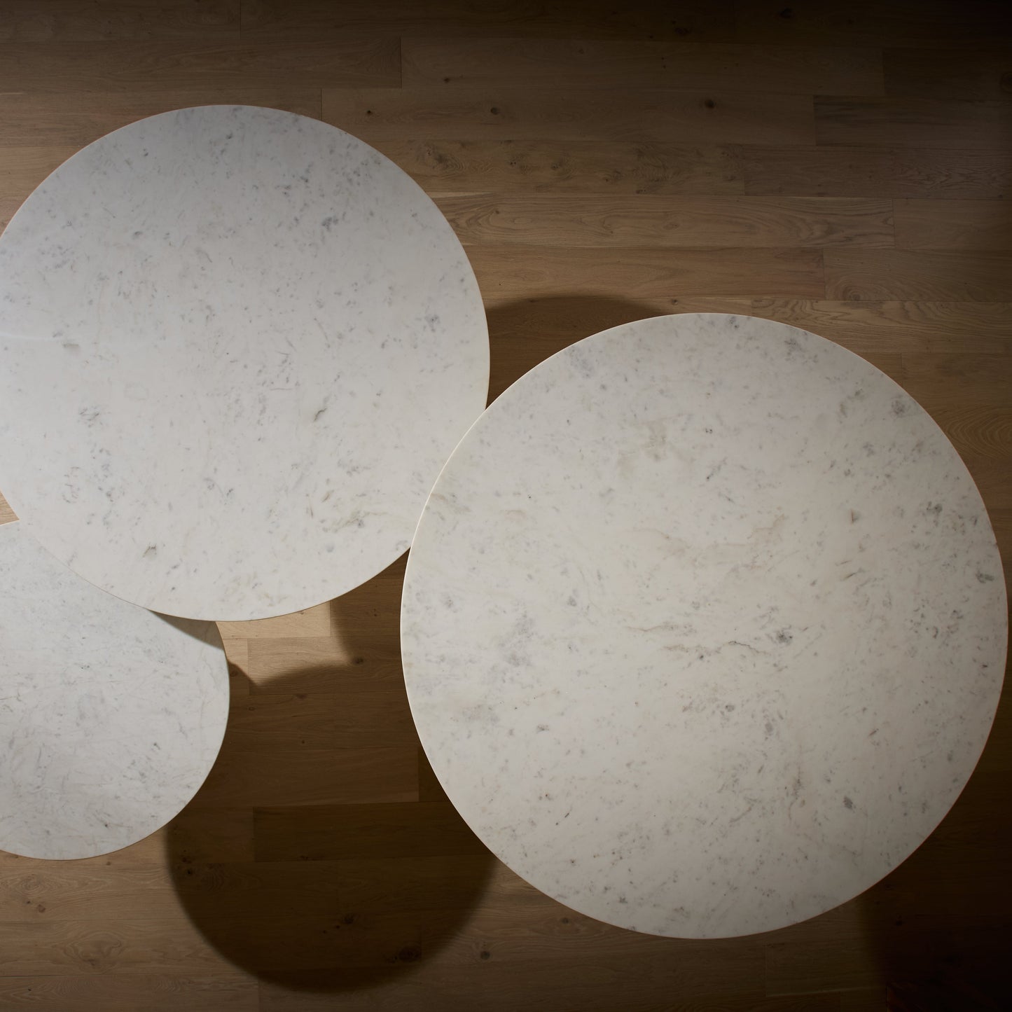 Three round, light-colored objects on a wooden floor