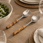 2 piece serving set with polished silver metal heads and warm brown wooden bamboo handles