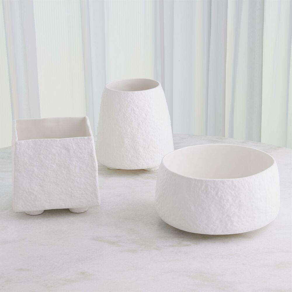 Three white textured planters of different shapes