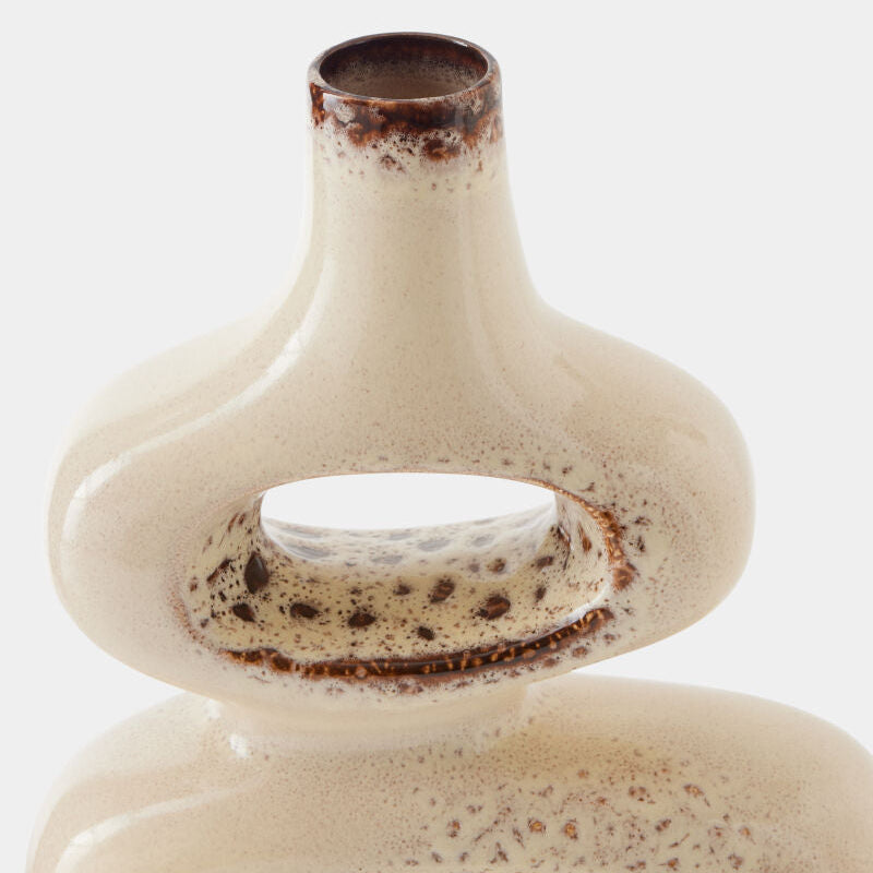 A close-up studio shot of a ceramic vase with a bulbous, rounded body and a narrow neck, featuring a glossy off-white glaze with brown speckled and mottled detailing around the rim and inside the central opening.