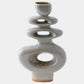 A modern stacked ceramic vase with a glossy gray glaze and metallic gold speckled accents inside the circular cutouts, set against a plain light gray background.