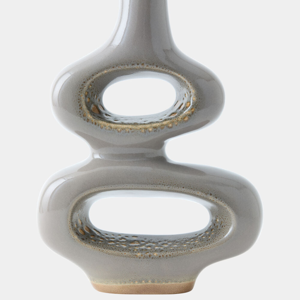A modern sculptural ceramic vase with a glossy taupe-gray finish and textured metallic gold accents, shown against a plain light gray background.