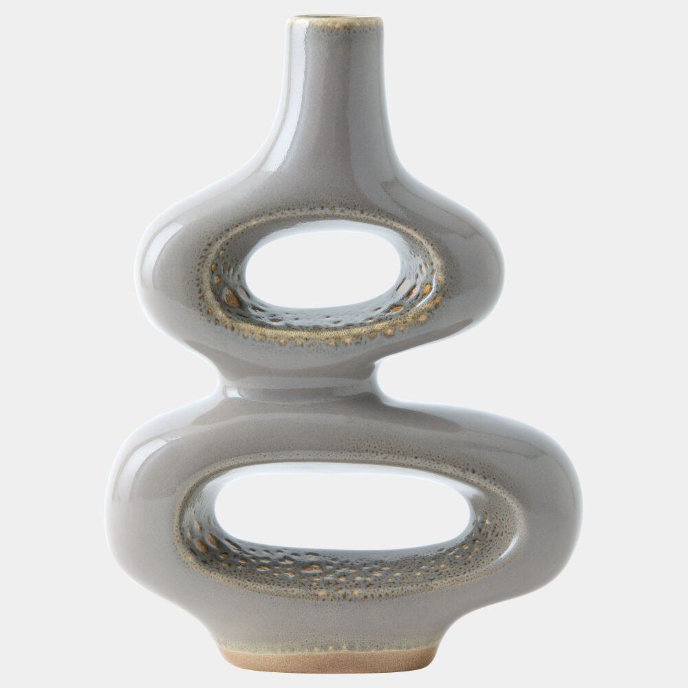 A modern, sculptural ceramic vase with a glossy light gray finish and textured metallic gold accents around the two central loops and base, set against a plain light gray background.