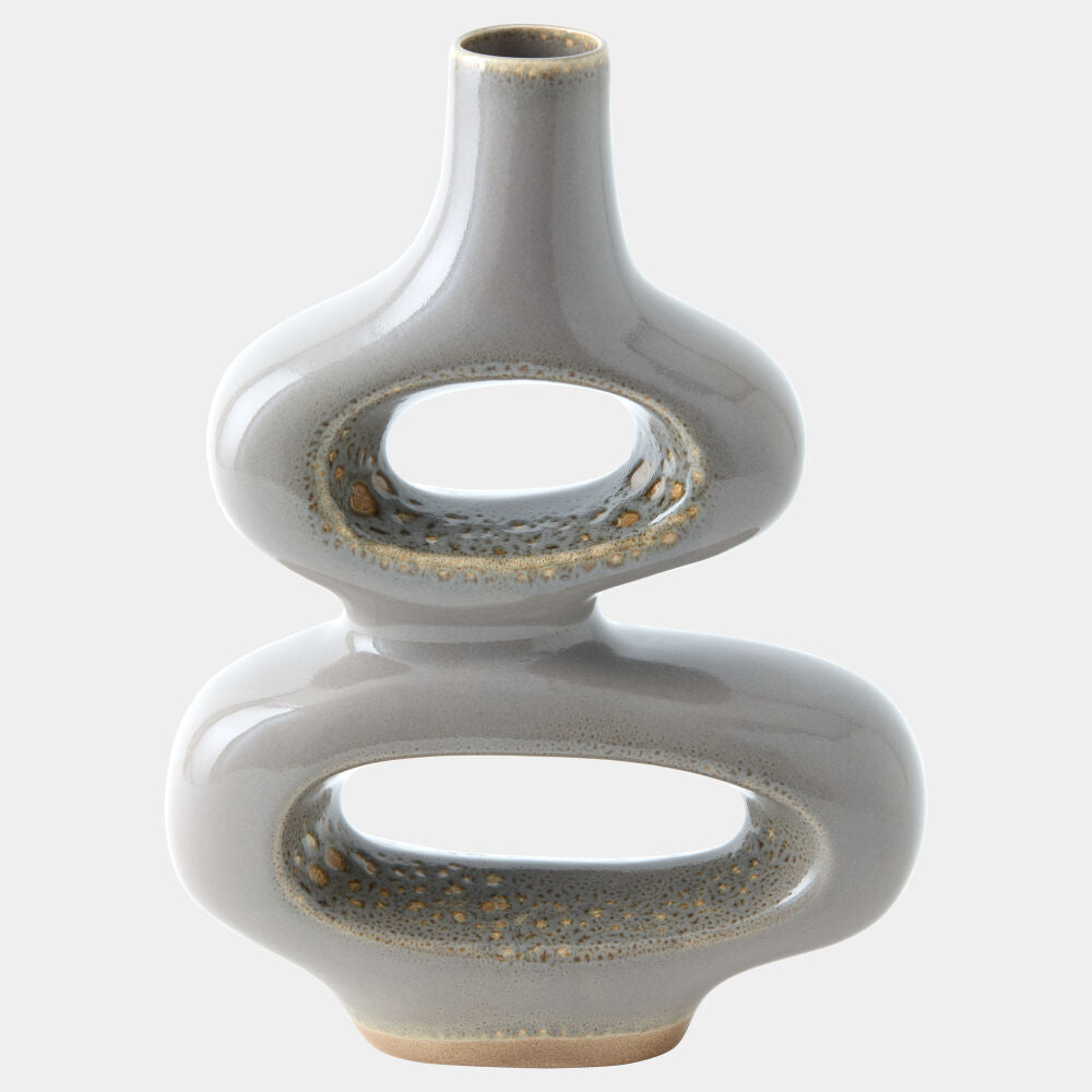 A modern, sculptural ceramic vase with a glossy light gray glaze and textured, speckled metallic gold-brown accents along the inner edges of its two interlocking oval rings, set against a plain light gray background.