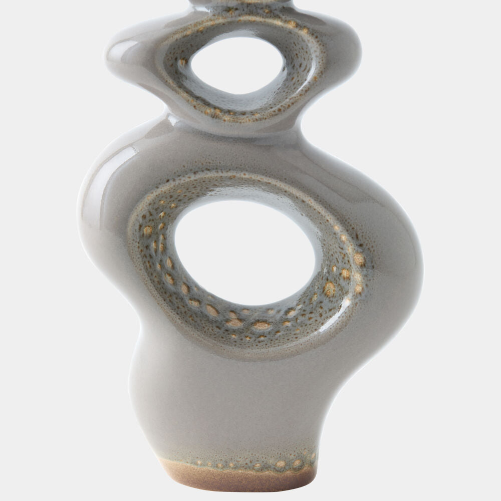 An abstract ceramic vase with a glossy light gray glaze and textured metallic gold accents around the cutout openings, shown against a plain light gray background.