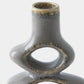 Close-up of a ceramic vase with a bulbous base and a narrow cylindrical neck, featuring a glossy gray-blue glaze with brown speckled accents, on a light gray background.