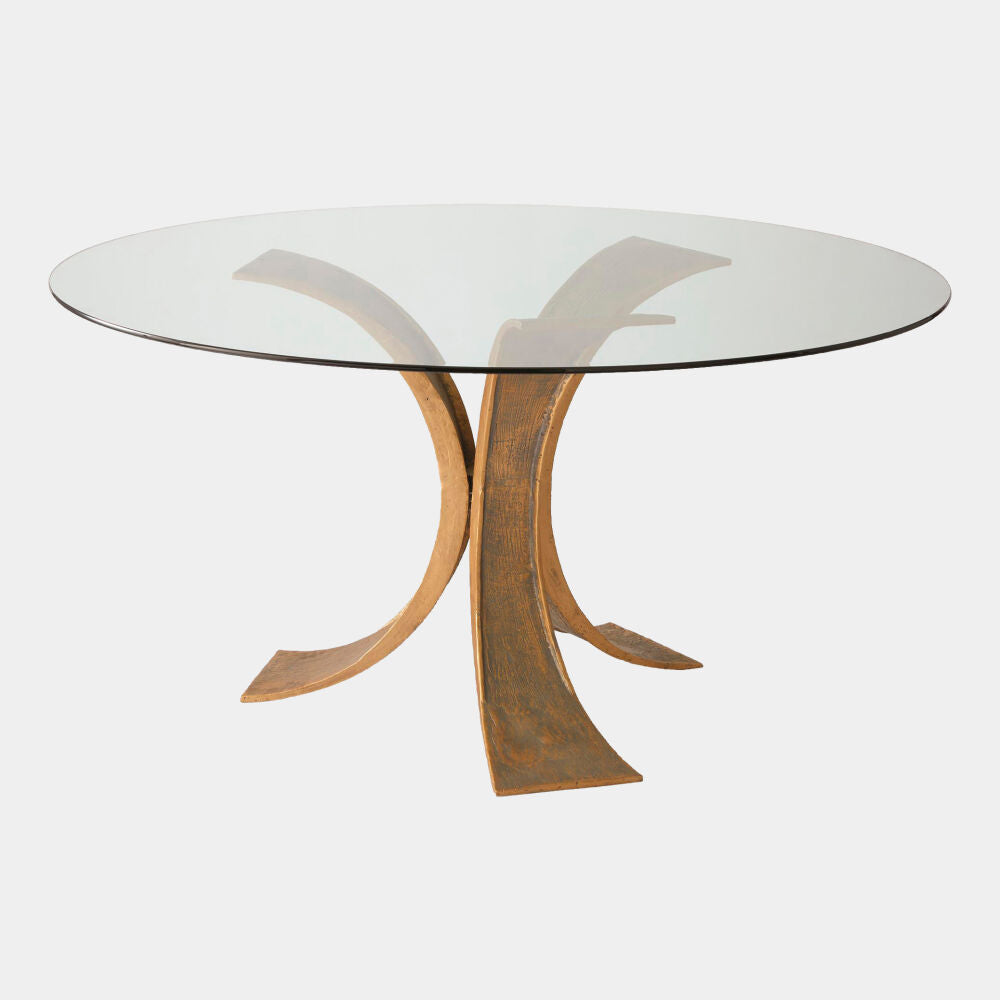 Glass dining table with a unique metal base on a white background