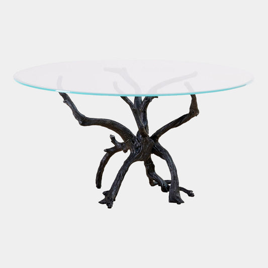 Glass top table with a natural branch base on a white background