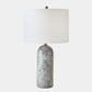 Table lamp with a gray marbled base and white shade on a light gray background