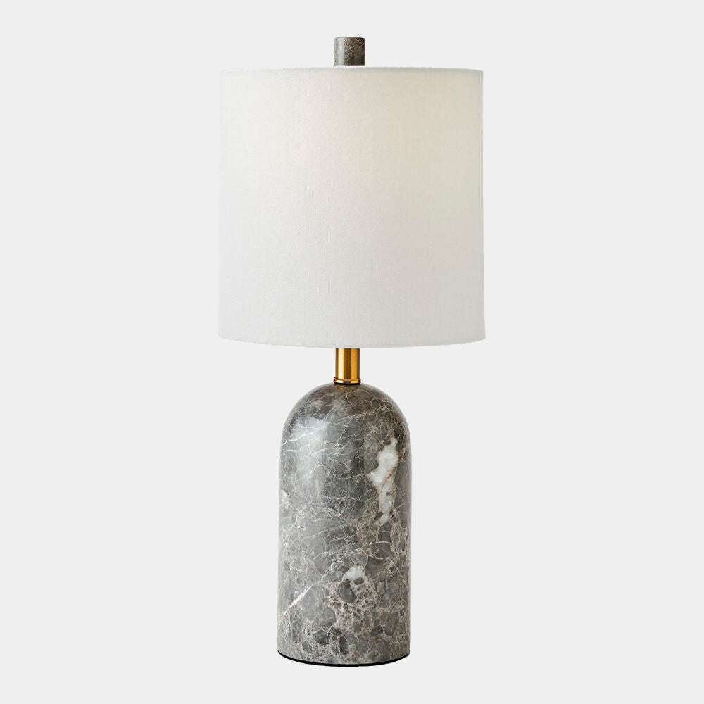 Table lamp with marble base and white shade on a light gray background