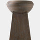A sculptural wooden pedestal stool with a wide, rounded bowl-like top and a tapered rectangular base, shown against a plain light gray background.
