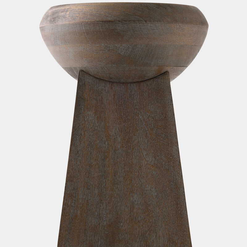 A sculptural wooden pedestal stool with a wide, rounded bowl-like top and a tapered rectangular base, shown against a plain light gray background.