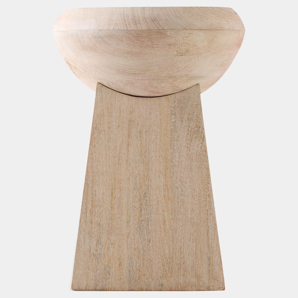 A minimalist wooden stool with a rounded bowl-shaped seat and a tapered rectangular pedestal base, crafted from light natural wood with visible grain.