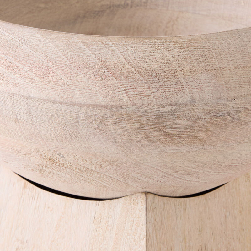 Close-up of a light natural wood bowl showing the grain texture and curved rim.