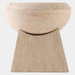 A light natural wood pedestal stool with a rounded bowl-shaped seat and a tapered rectangular base, shown against a plain light gray background.