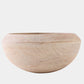 A round wooden bowl with a natural light beige finish and visible wood grain, photographed against a solid light gray background.
