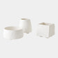 Three white textured planters of different shapes on a light gray background