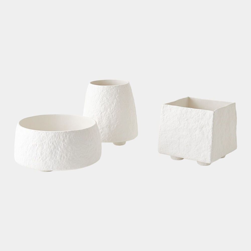 Three white textured planters of different shapes on a light gray background