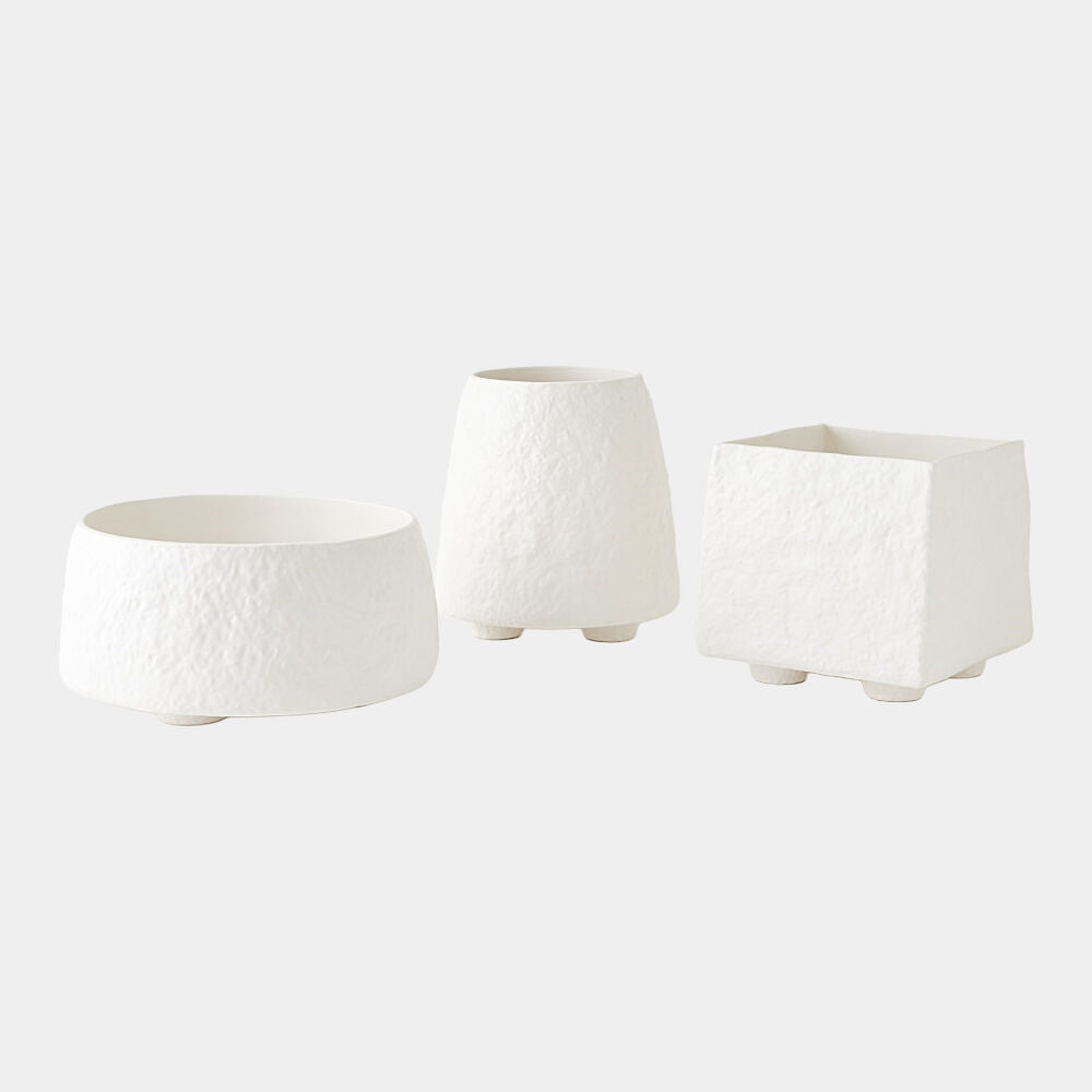 Three white textured planters of different shapes on a light gray background