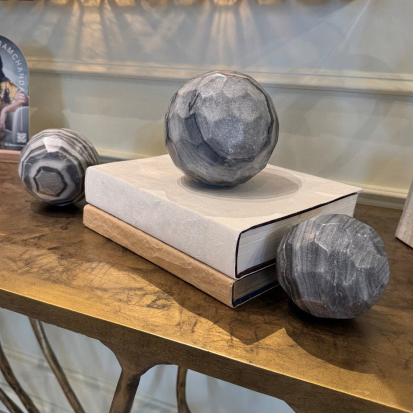 Decorative objects on a table with a mirror and book in the background