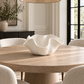 white sculptural ceramic bowl in the center of a dining table