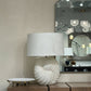 Decorative lamp on a wooden cabinet with a mirror and chandelier in the background