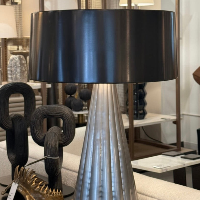 Decorative table lamp with a black shade and metallic base in an indoor setting