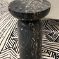 Black marble side table on a patterned rug
