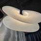 Three white textured objects stacked on a reflective surface