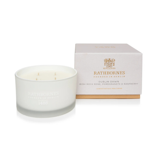 White candle in a glass holder with a Bathborne's branded box on a white background