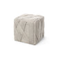 Textured cube-shaped ottoman on a white background