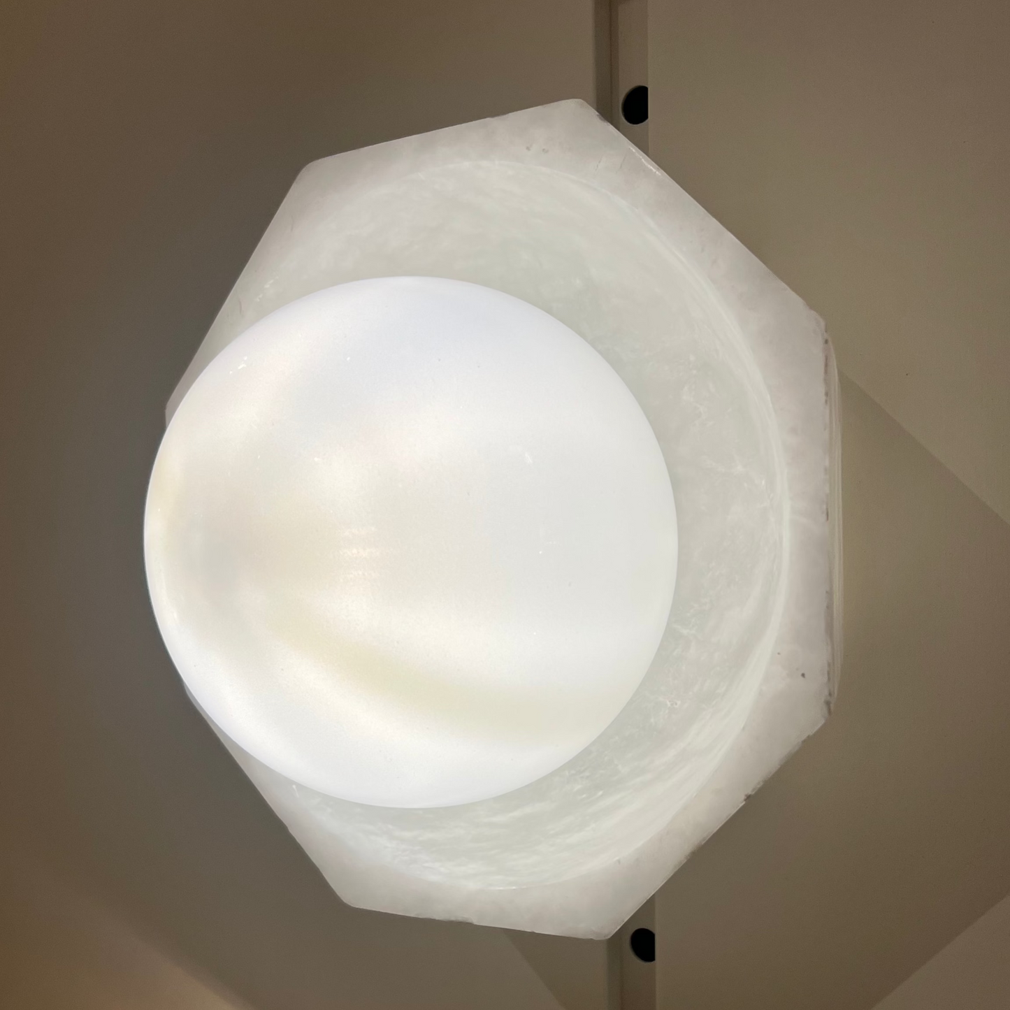 Hexagonal wall light fixture on a neutral background